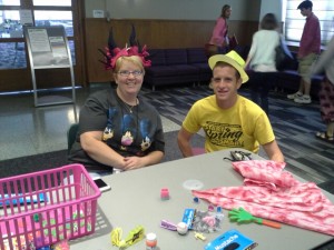 Melissa Mueller passes out prizes to campers wearing hats.