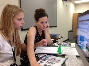 Sara-Beth Badalamente directs one of her students toward creating a layout to insert in her newspaper. 